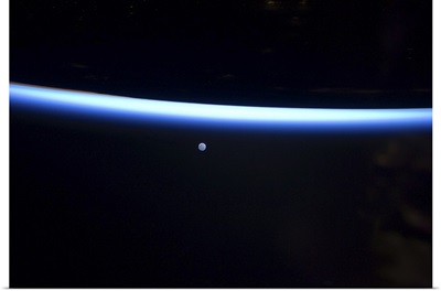 Earth's thin line of atmosphere and a gibbous moon