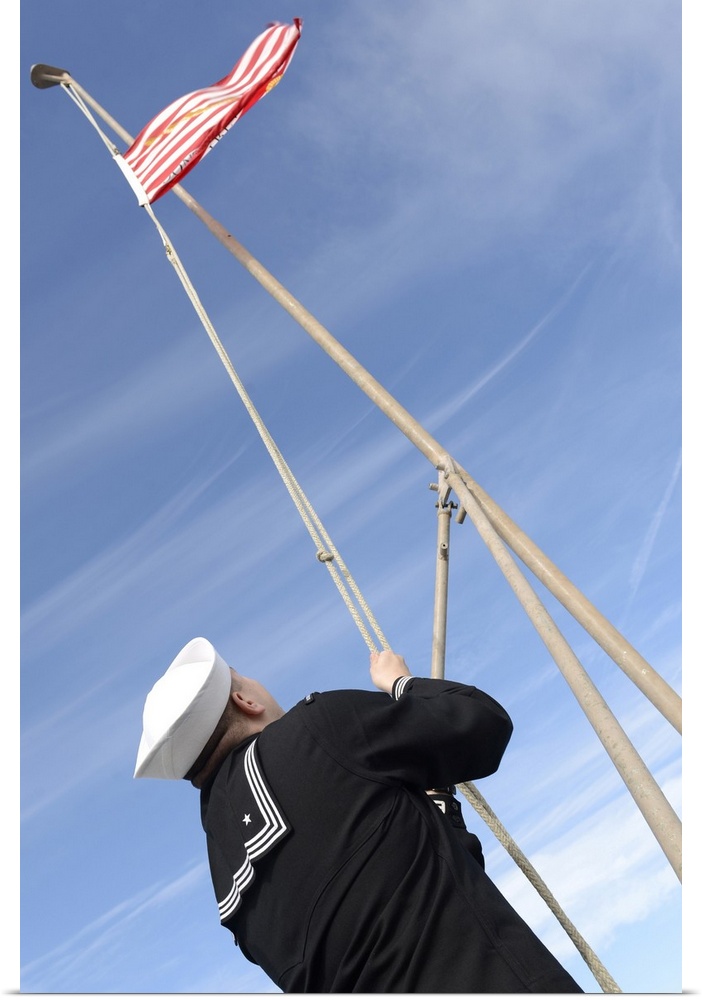 Mayport, Florida, December 11, 2014 - Electronics Technician lowers the Union Jack on the flight deck aboard Wasp-class am...