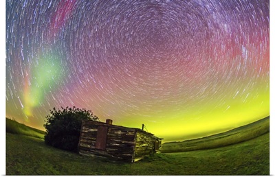 Fish-eye lens composite of aurora and circumpolar star trails above ranch in Canada