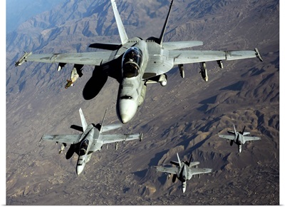 Four U.S. Navy F/A 18 Hornet aircraft fly over mountains in Afghanistan