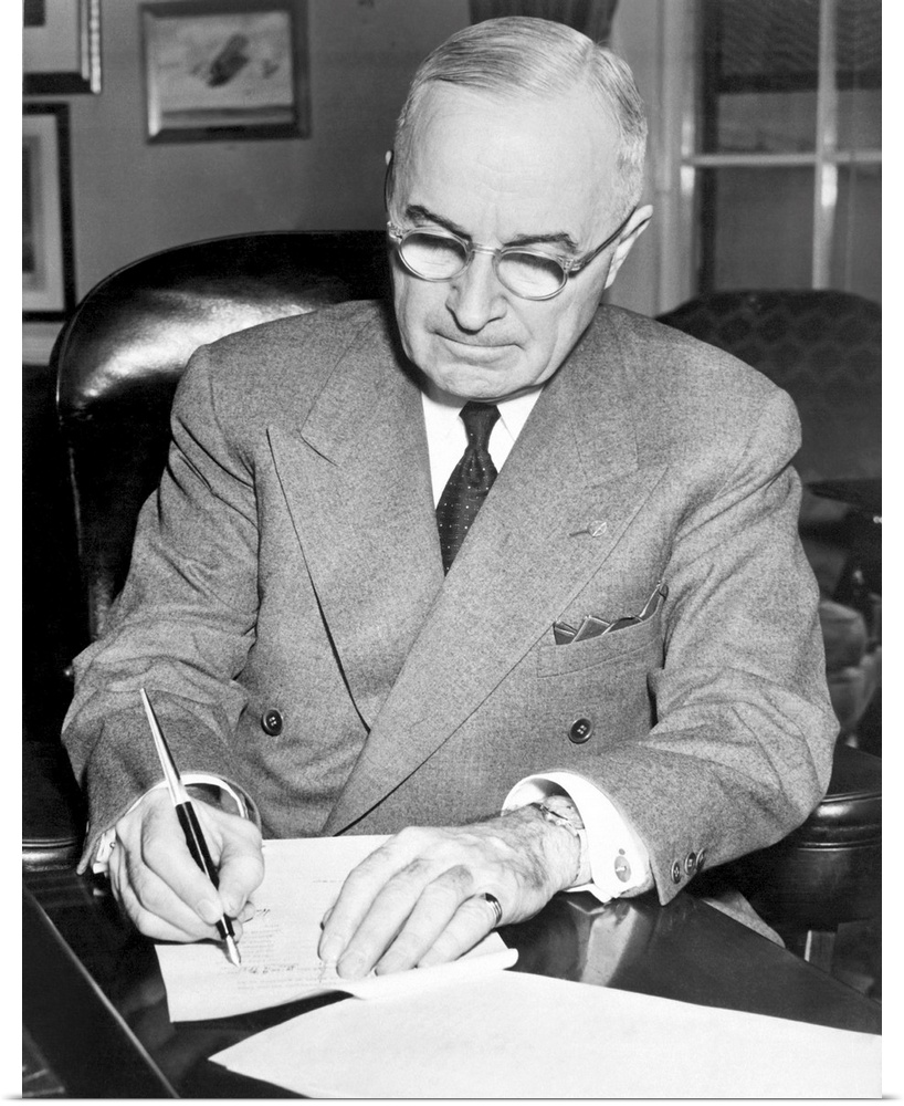 President Harry Truman signing a document allowing American involvement in the Korean War, 1950.