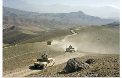 Humvees traverse rugged mountain roads