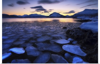 Ice flakes drifting against the sunset in Tjeldsundet strait, Troms County, Norway