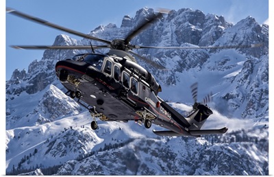Italian Arma Dei Carabinieri AW-139 Helicopter Flys By A Snowcapped Mountain In Italy