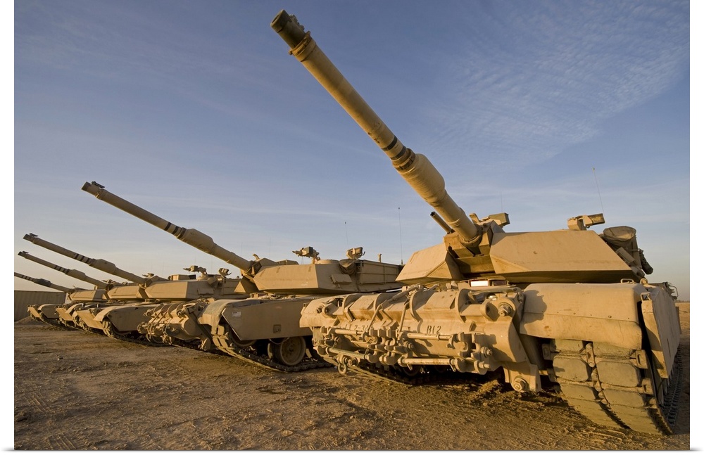 Photograph taken of large military tanks parked in the desert.