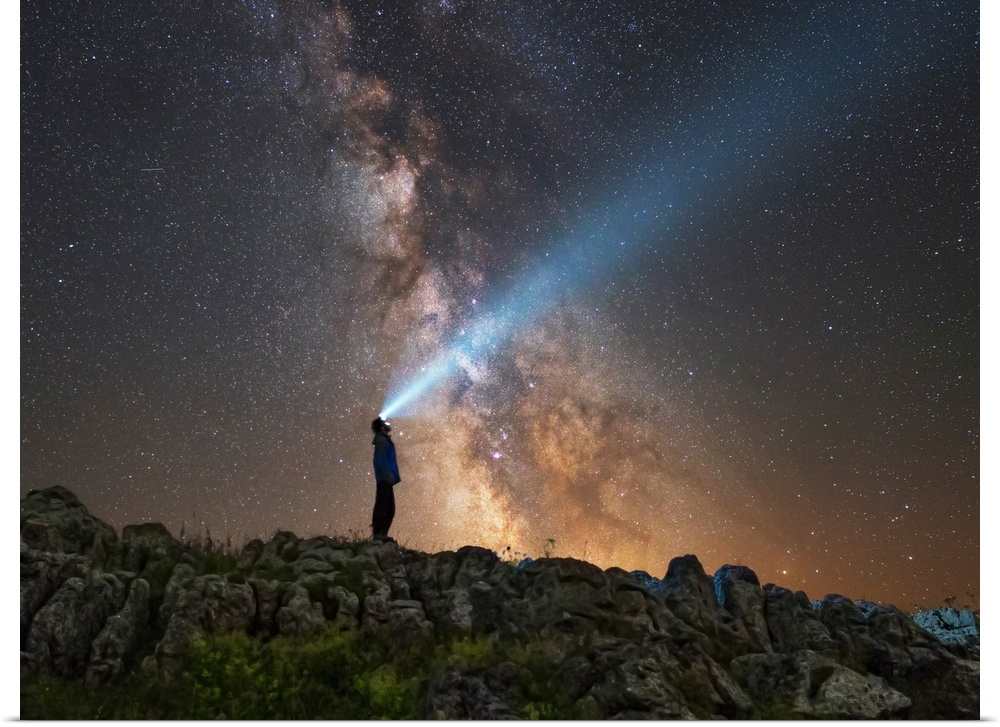 Man shining a flashlight on the Milky Way from Lago-Naki plateau in Russia.