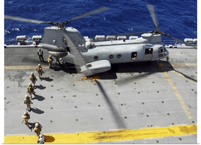 Marines Board A CH-46E Sea Knight Helicopter On The Flight Deck Of USS Peleliu