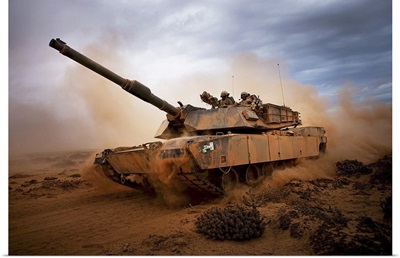 Marines roll down a dirt road on their M1A1 Abrams Main Battle Tank