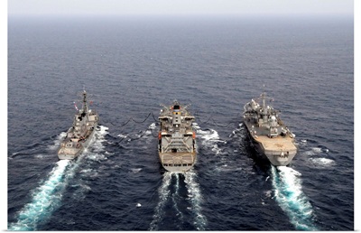 Military ships conduct an underway replenishment in the Pacific Ocean