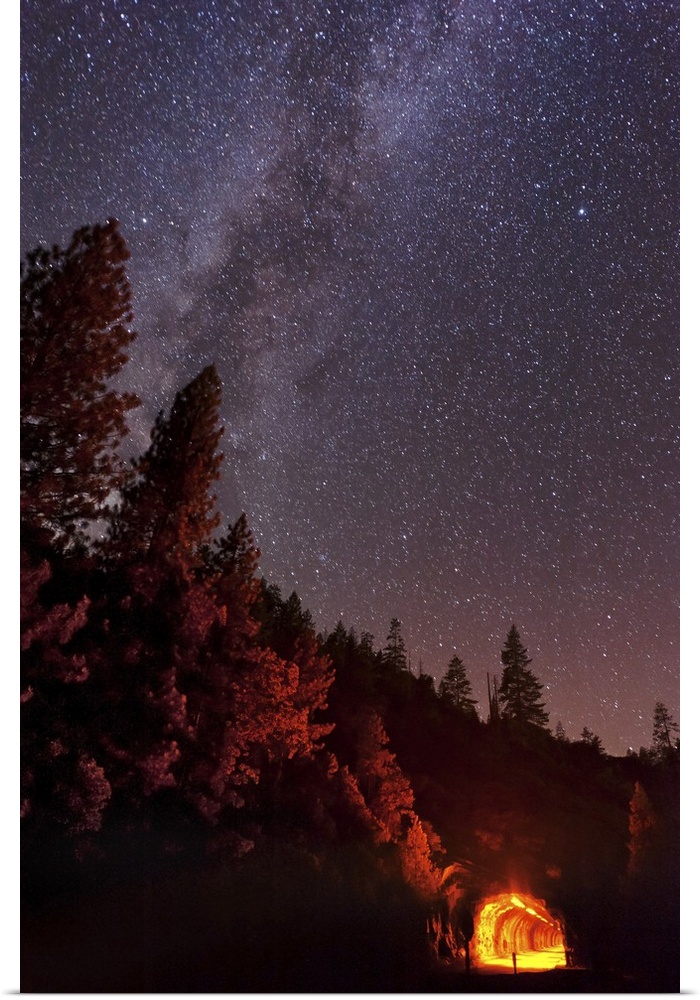 The summer Milky Way rises over the mountain while the tunnel blazes with light in this long exposure photo taken at Yosem...