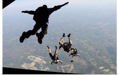 Navy SEALs jump from the ramp of a C-17 Globemaster III over Virginia