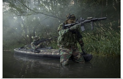 Navy SEALs navigate the waters in a folding kayak during jungle warfare operations