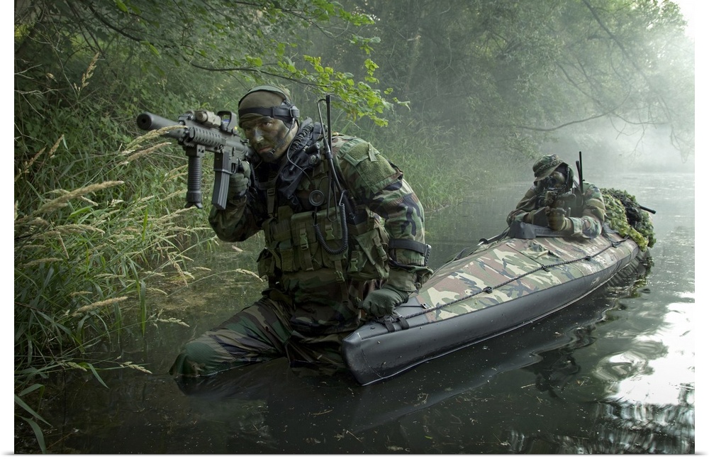 A dramatic photograph of soldiers as they walk through water armed and ready.