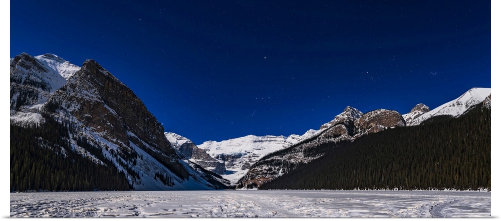 Orion setting over the iconic Victoria Glacier at Lake Louise, frozen here in March, and with the scene lit by the light o...