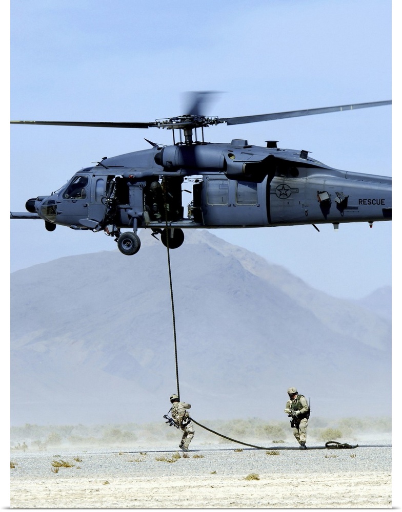 Pararescuemen descend from an HH-60 Pave Hawk helicopter.