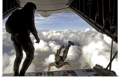 Pararescuemen jump out the back of a C130 Hercules