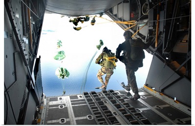 Pararescuemen perform a static-line jump out of a C-130 Hercules