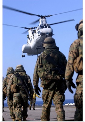 Personnel Walk Toward A CH-46E Sea Knight Helicopter
