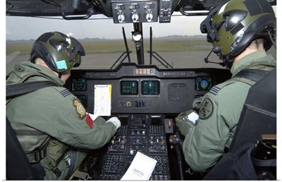 Pilots inside the cockpit of a Royal Air Force Merlin Helicopter at RAF Lyneham