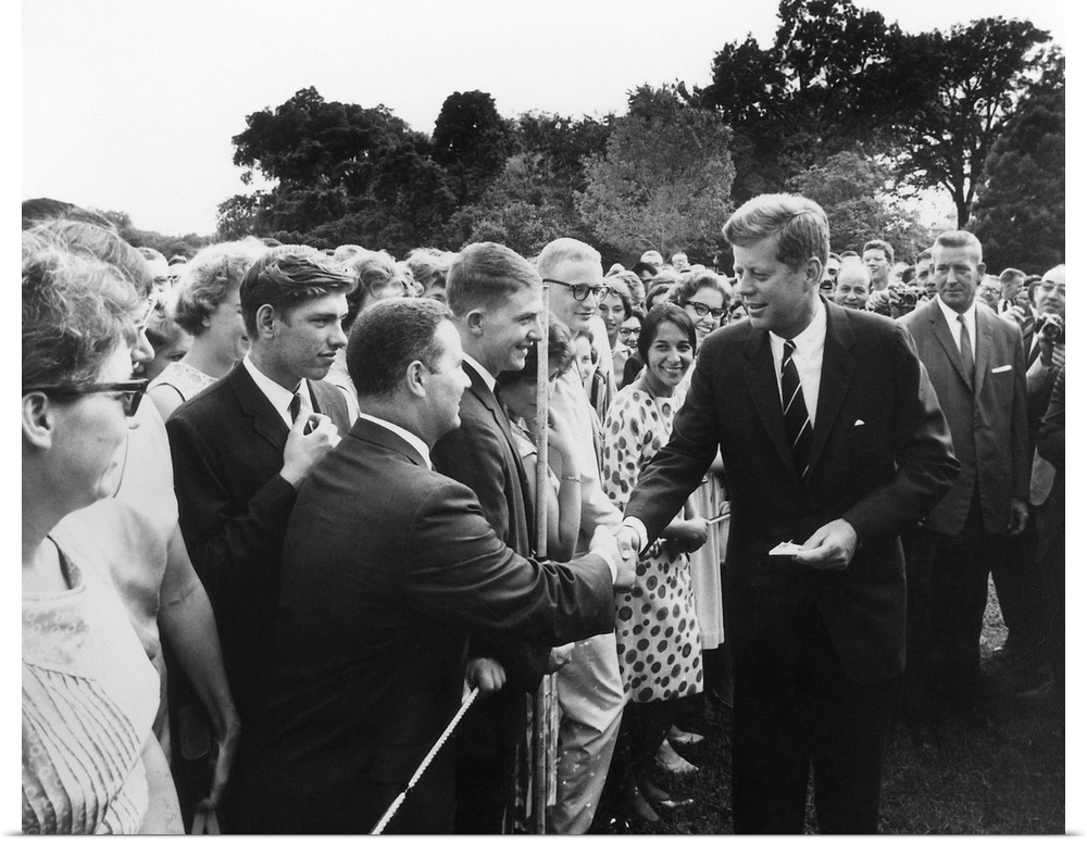 President Kennedy greets Peace Corps Volunteers on the White House South Lawn.