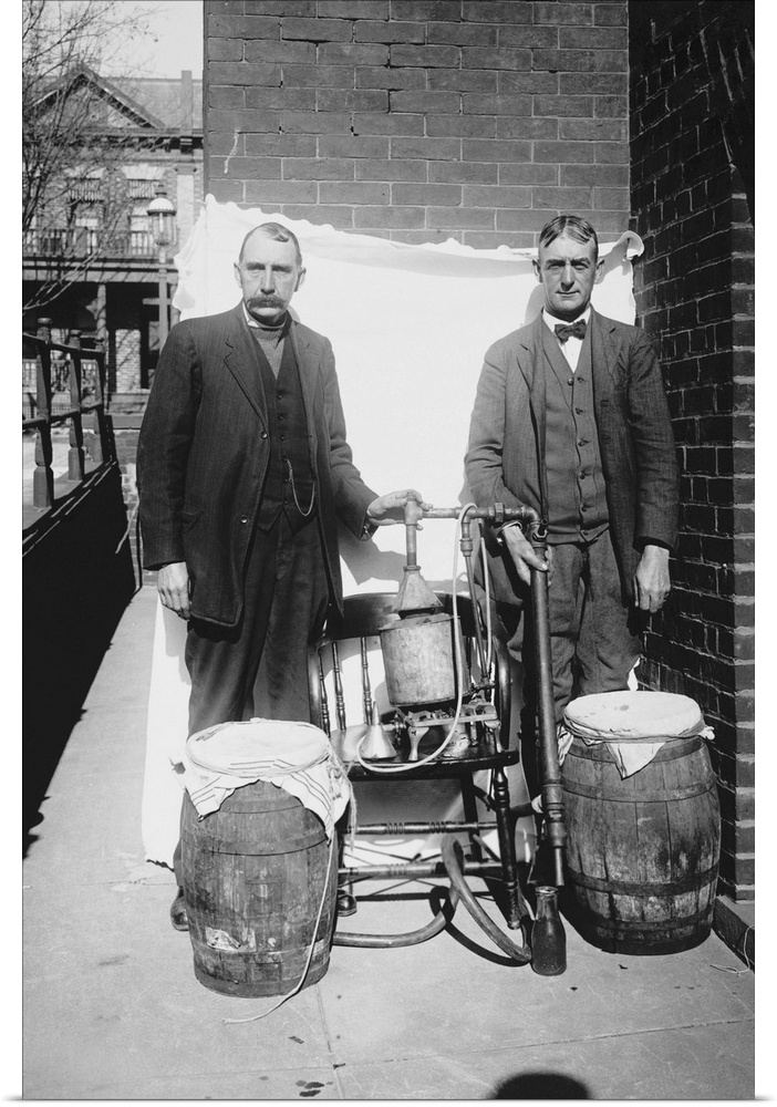 Prohibition era photograph of two men posing with an illegal whiskey still.