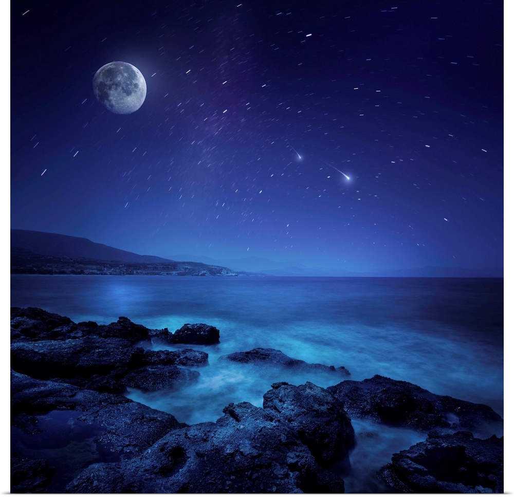 Rocks seaside against rising moon and starry field, Crete, Greece.