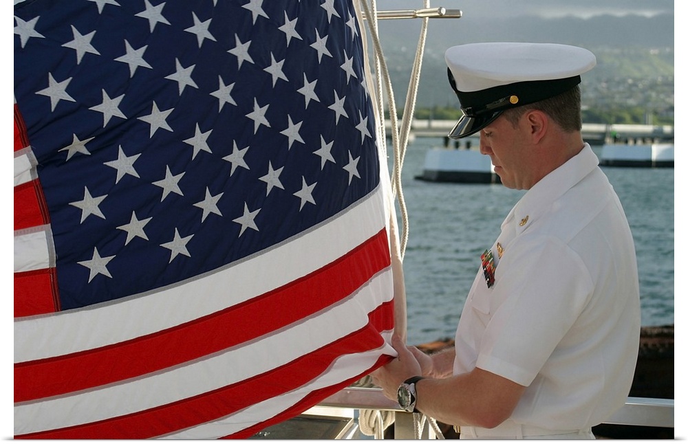 Sailor raises an American flag above the USS Arizona Memorial in Pearl Harbor, Hawaii.