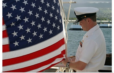 Sailor raises an American flag above the USS Arizona Memorial in Pearl Harbor, Hawaii
