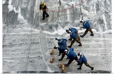 Sailors conduct a Scrub Exercise on the flight deck aboard USS Peleliu