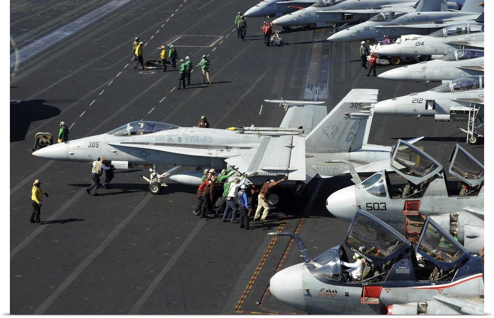 October 30, 2012 - Sailors push an F/A-18C Hornet in preparation for flight operations aboard the Nimitz-class aircraft ca...