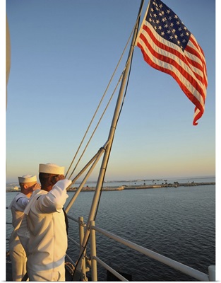 Sailors salute the national ensign aboard USS Bataan