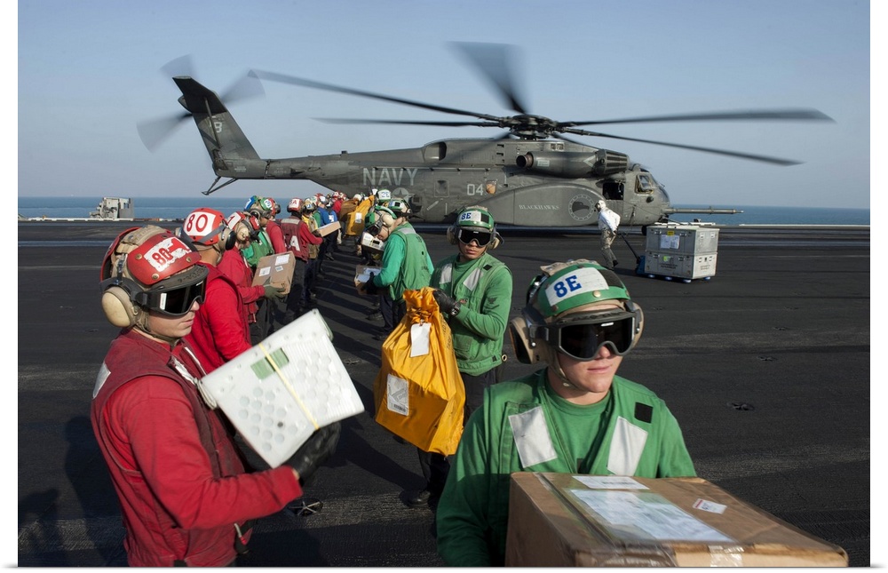 Arabian Gulf, December 19, 2013 - Sailors unload mail from an MH-53E Sea Dragon helicopter on the flight deck of the aircr...