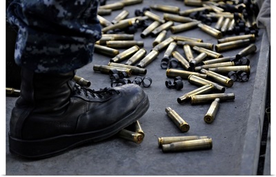 Shell Casings From A 50 Caliber Machine Gun Around The Feet Of A Soldier