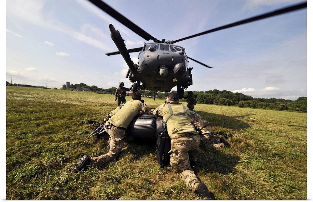 July 24, 2014 - Soldiers mount an inflatable Zodiac boat to the bottom of a HH-60 Pave Hawk helicopter.