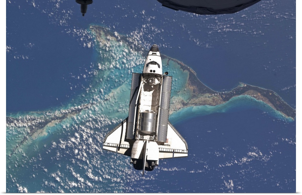July 10, 2011 - Space Shuttle Atlantis over the Bahamas. Part of a Russian Progress spacecraft is visible in the foreground..