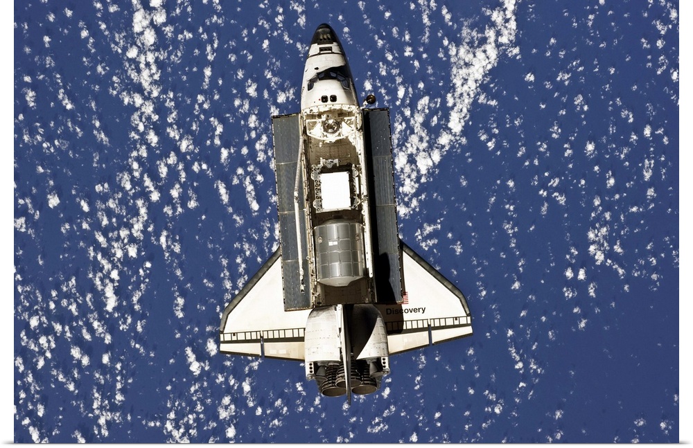 February 26, 2011 - Backdropped by a blue and white part of Earth, space shuttle Discovery is featured in this image photo...