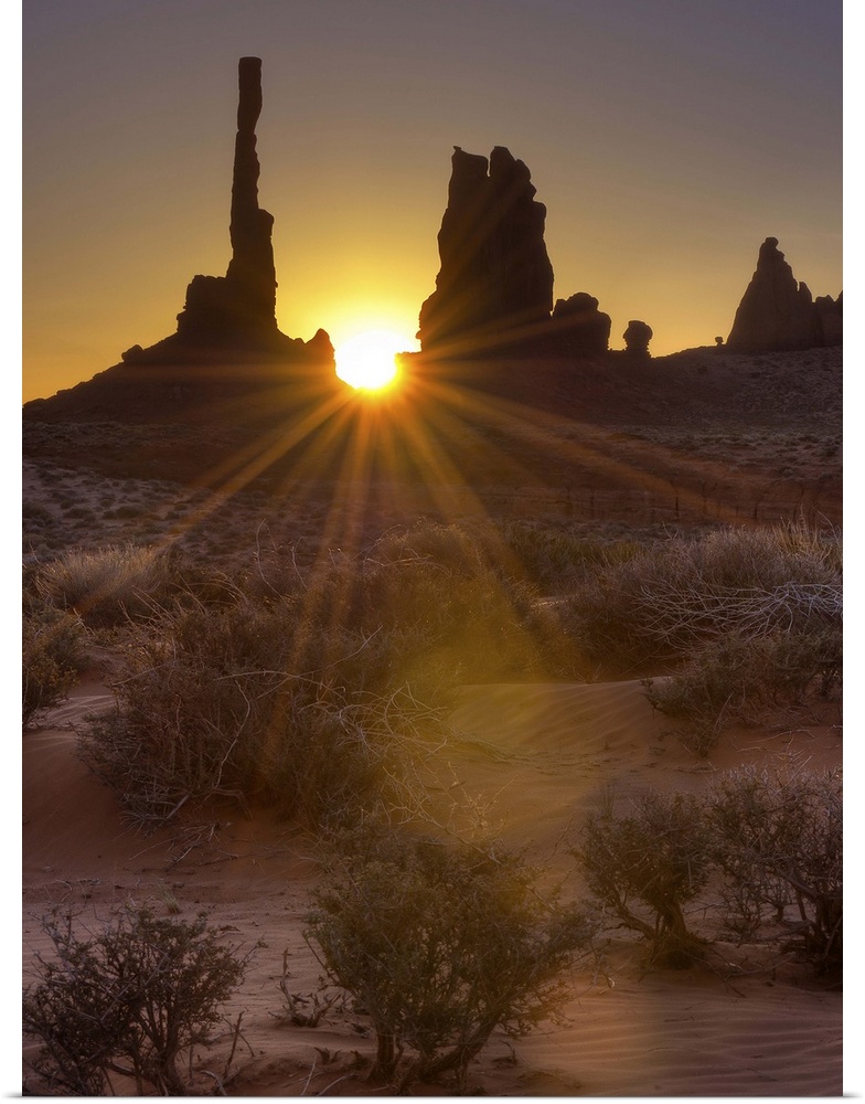 A sunburst through the famous Totem Pole formation in Monument Valley, Utah.