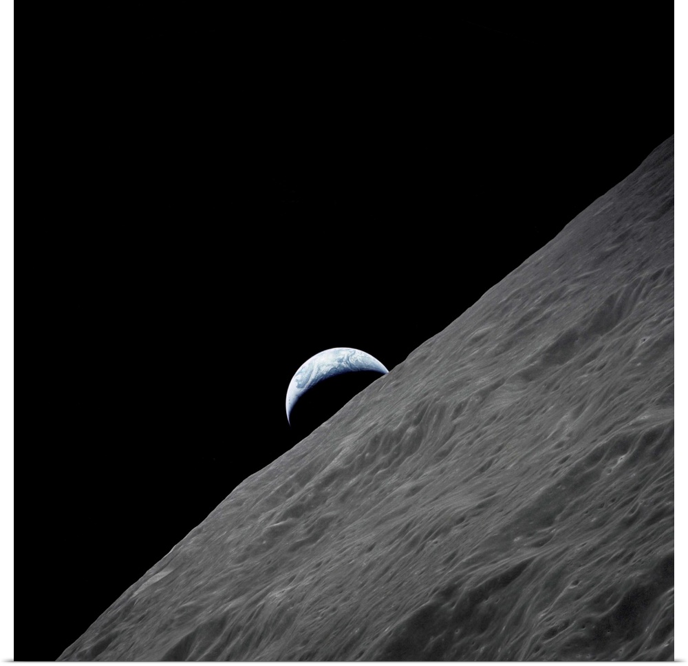 The crescent Earth rises above the lunar horizon