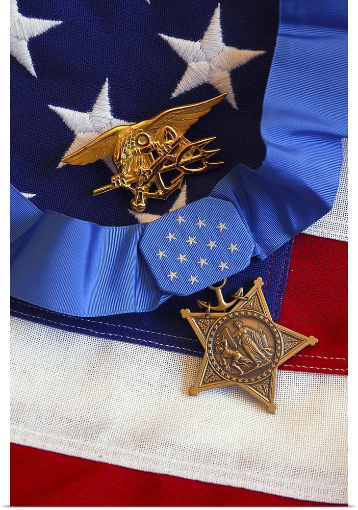 The Medal of Honor rests on a flag beside a SEAL trident during preparations for an award ceremony