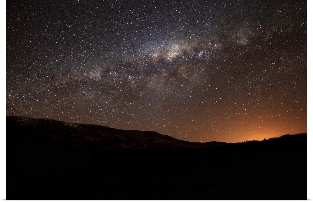 The Milky Way setting behind the hills of Azul, Argentina, part of the Tandilia Hills. The light dome of the city of azul ...