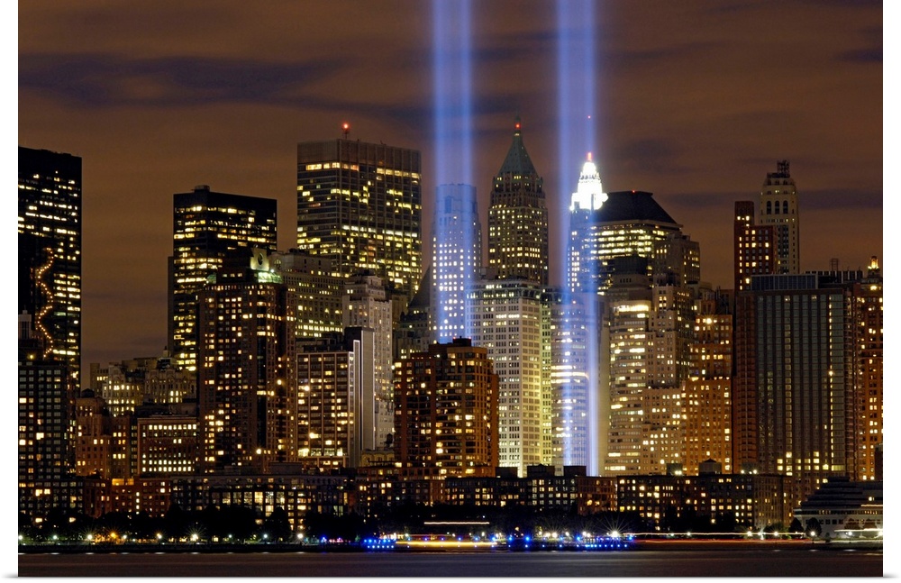 Two memorial rectangular lights shoot up into the night sky in NY symbolizing the two World Trade Center towers.