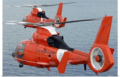 Two Coast Guard HH 65C Dolphin helicopters fly in formation over the Atlantic Ocean