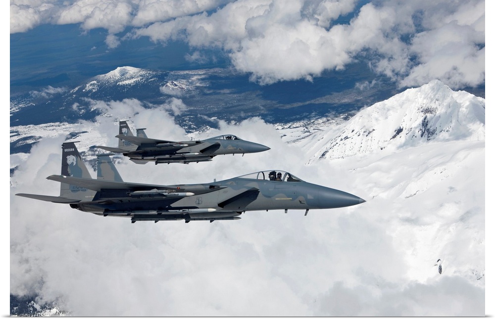 Two F-15 Eagles from the 173rd Fighter Wing fly past snow capped peaks in Central Oregon.