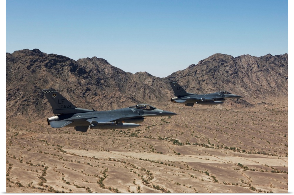 Two F-16's from the 56th Fighter Wing at Luke Air Force Base, Arizona, fly in formation while flying low level over the Ar...