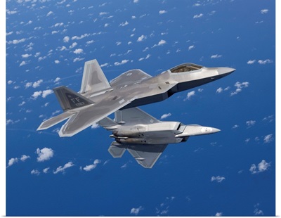 Two F-22 Raptors maneuver while flying a training mission over Japan