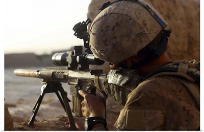 U.S. Marine looks through the scope of his M16A4 rifle for enemy forces