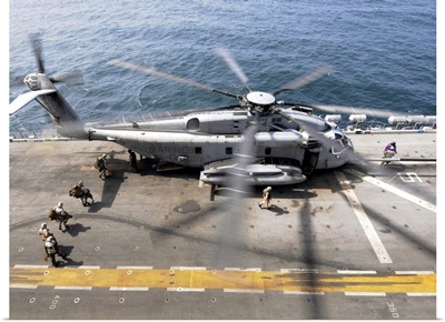 U.S. Marines board an MH 53E Sea Dragon helicopter aboard the USS Peleliu