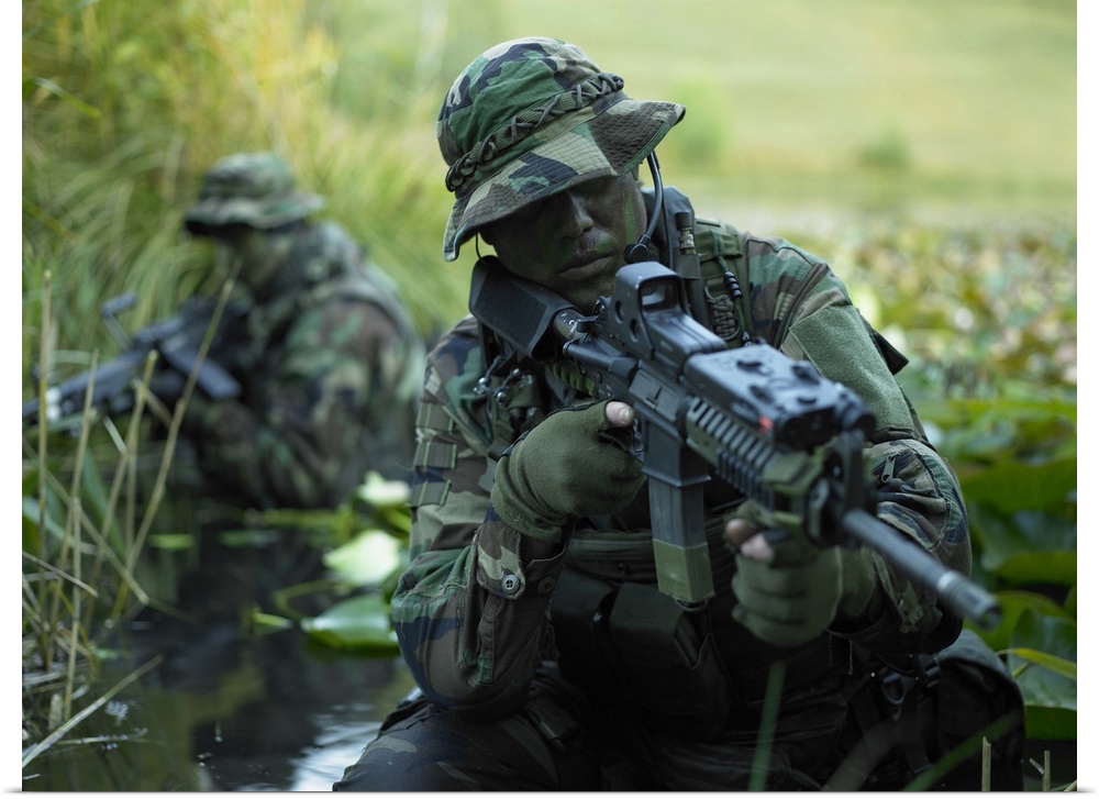 U.S. Navy SEALs cross through a stream during combat operations.