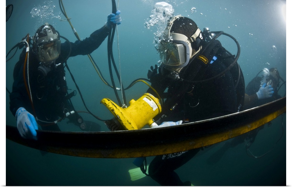 May 27, 2010 - U.S. Navy Diver instructs a Barbados coast guard diver on using a hydraulic grinder underwater during Navy ...