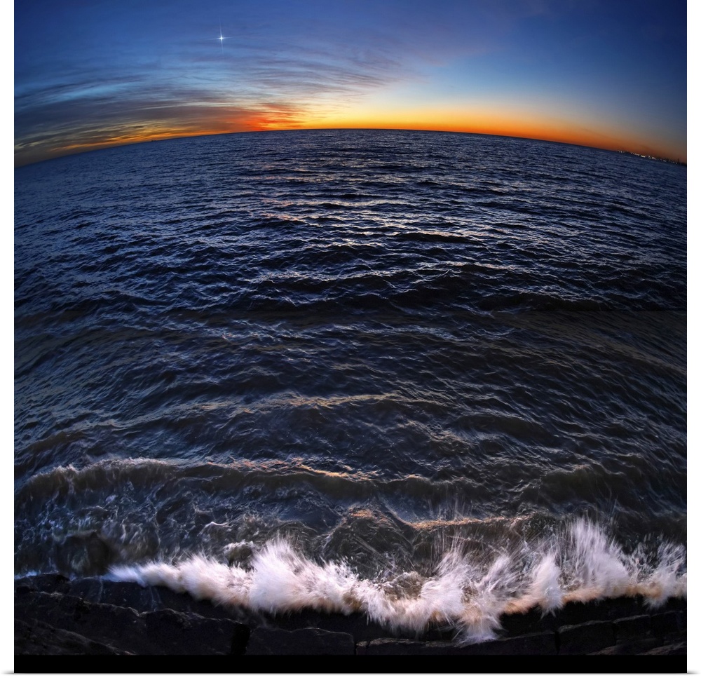 Venus shines brightly in the sky just a few minutes before sunrise, while waves from Rio de La Plata crash at the shorelin...